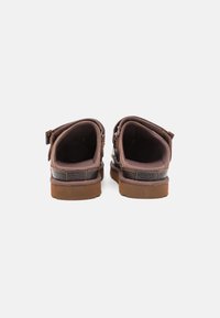Bruine leren schoenen met een lage profiel, ronde vorm en zachte voering. Voorzien van een rubberen zool en contrasterend stikseldetail.