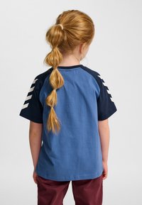 Blå och marinblå kortärmad t-shirt med rund halsringning; har vita ränder på de marinblå ärmarna; bomullsmaterial.