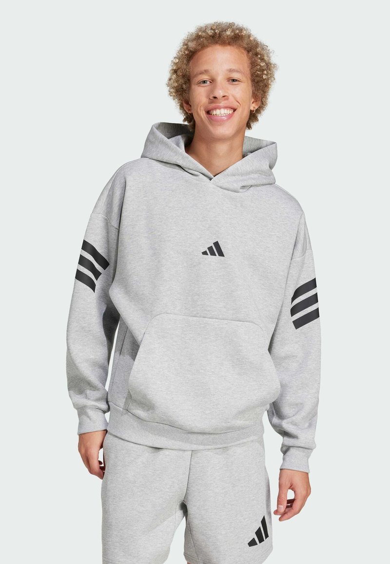 Sweat à capuche gris avec une poche frontale, présentant des logos Adidas noirs et trois bandes noires sur chaque bras. Tissu léger, design décontracté.