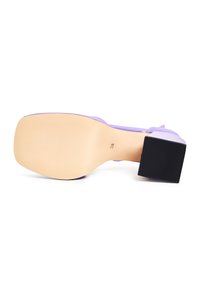 Sandalo viola con tacco alto quadrato nero, finitura liscia e suola beige texturizzata dotata di righe antiscivolo per una migliore aderenza.