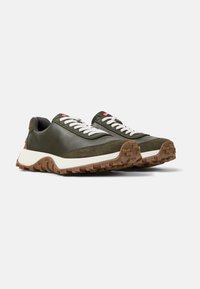 Sneaker verde oliva realizzate in pelle e tessuto, con lacci bianchi, una robusta intersuola bianca e una suola esterna in gomma marrone testurizzata.
