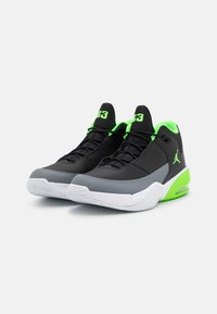Black and gray athletic shoes with a breathable upper, green accents, and Air cushioning. Features textured sole and logo on the side.