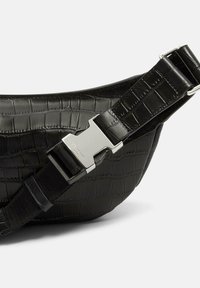 Czarna skórzana nerka o teksturze krokodyla, z metalowym zapięciem w kolorze srebrnym i regulowanym czarnym paskiem.