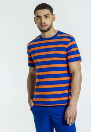 T-shirt rayé bleu et orange, avec un col rond, des manches courtes et un petit logo sur la poitrine. Le textile est en coton lisse.