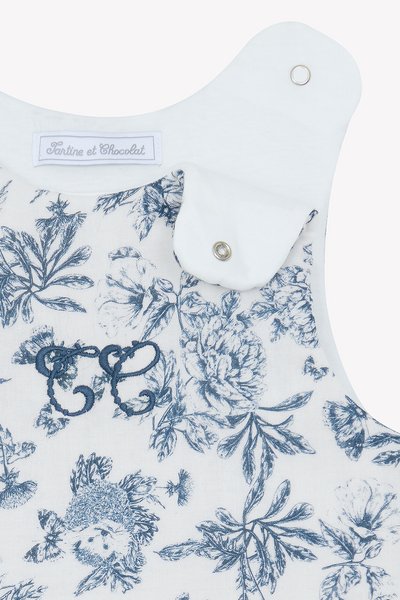 Ρούχο με μπλε και λευκό λουλουδάτο σχέδιο, στρογγυλή λαιμόκοψη, διακοσμητική κεντήματα και κουμπώματα snap στον ώμο.