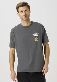 Grå t-skjorte i bomull med grafikk, med en blå og gul tegneseriefigur på venstre bryst. Korte ermer og rund hals.