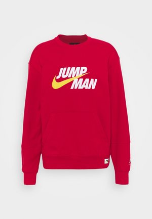 Czerwona bluza z długim rękawem i kieszenią z przodu, z wyraźnym białym napisem "JUMP MAN" oraz żółtym logo w kształcie zawiniętej linii na piersi.