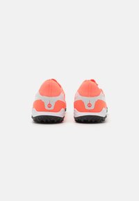 Pantofi sport cu un superior de culoare corali strălucitor, accente albe și talpă texturată neagră. Au un fit strâns și un design minimalistic pe călcâi.