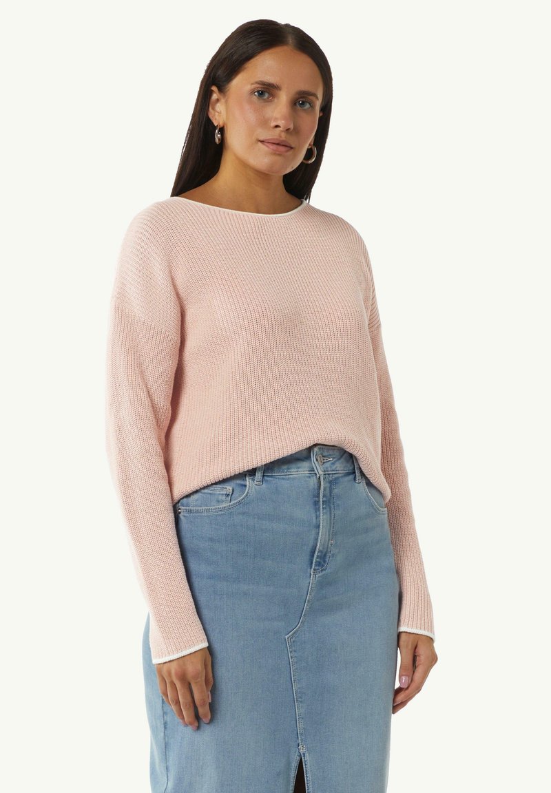 Light pink knit sweater with a relaxed fit, scoop neckline, and long sleeves paired with a light blue denim skirt featuring a front slit.