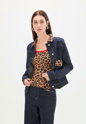 Chaqueta vaquera con un forro de estampado de leopardo, que presenta un cuello con solapas y botones plateados, combinada con un top marrón de estampado de leopardo.
