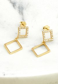 Orecchini quadrati in oro, caratterizzati da un quadrato più piccolo adornato con strass trasparenti, sospeso da un quadrato più grande e testurizzato in oro sottostante.