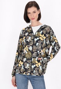 Bloemrijke zip-up jas met een zwarte achtergrond, gele en blauwe botanische print, capuchon en zakken. Gemaakt van gladde, lichte stof.