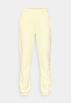 Gele joggingbroek gemaakt van zachte stof, met een elastische tailleband en taps toelopende boorden, een gladde textuur en zonder zichtbare patronen.