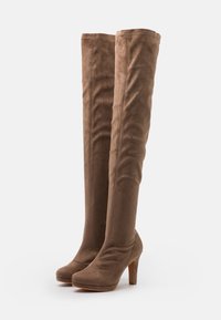 Botas de ante marrón hasta la rodilla con plataforma y tacón alto, que presentan una textura suave y sutiles detalles de costura.