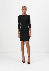 Černé bodycon šaty s dlouhými rukávy, přiléhavý střih, texturovaná látka, délka ke kolenům, se zajímavým švem na korzetu.