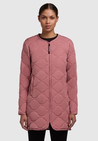 Manteau matelassé rose clair avec un col rond, fermeture éclair et poches latérales. Motif texturé avec des formes ondulées tout au long.