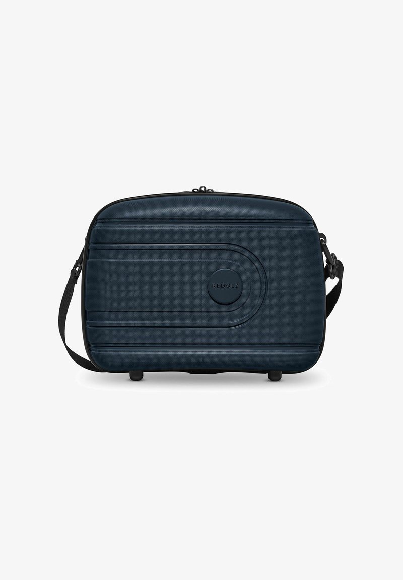 Donkerblauwe rechthoekige tas met textuur, ritssluiting, verstelbare schouderband en rond logo detail. Geschikt voor reizen of opslag.