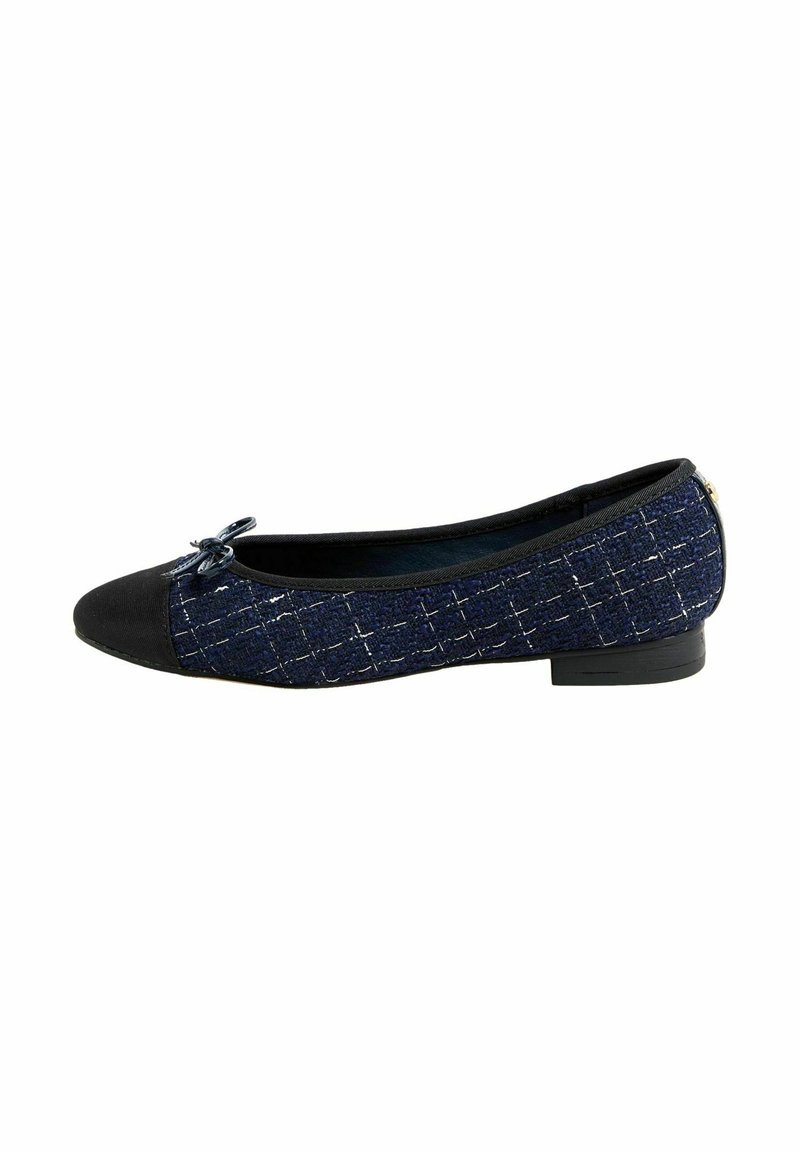 Marineblaue flache Schuhe mit einem strukturierten Muster, einer schwarzen Kappe und einem kleinen Schleifendetail auf dem Vorderfuß, vor einem weißen Hintergrund.
