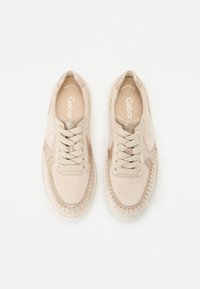Chaussures de sport en daim beige avec surpiqûres texturées, design à bout rond et lacets assortis. Nom de la marque "Gabor" visible à l'intérieur.