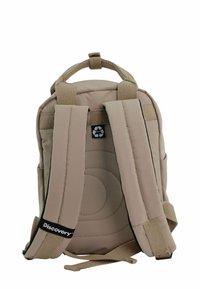 Brauner Rucksack mit gepolsterten Schulterriemen, einem Tragegriff an der Oberseite und einem kreisförmigen gesteppten Design auf der Rückseite. Verfügt über ein recyceltes Logo auf dem Etikett.