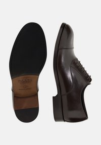 Scarpa elegante in pelle marrone con una finitura liscia, allacciatura chiusa e punta arrotondata. Presenta una suola in gomma nera con marchio impresso.