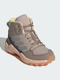 High-top athletic shoes in gray mesh with light yellow accents, featuring a textured surface, lace-up design, and rubber outsole.