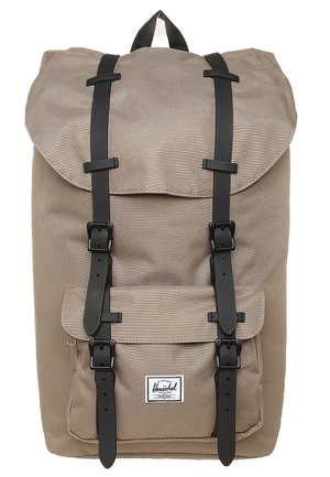 Beiger Stoffrucksack mit schwarzen Schnallenriemen, Fronttasche und Tragegriff oben, mit einem weißen rechteckigen Markenlabel auf der Tasche.
