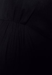 Tecido preto com uma superfície texturizada, apresentando detalhes franzidos. O material é suave, e a cor é uniforme, sem padrões ou acentos.