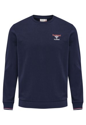 Granatowa bluza crewneck z długimi rękawami, ściągaczami przy mankietach i dole, z małym czerwono-białym logo hummel na lewej piersi.