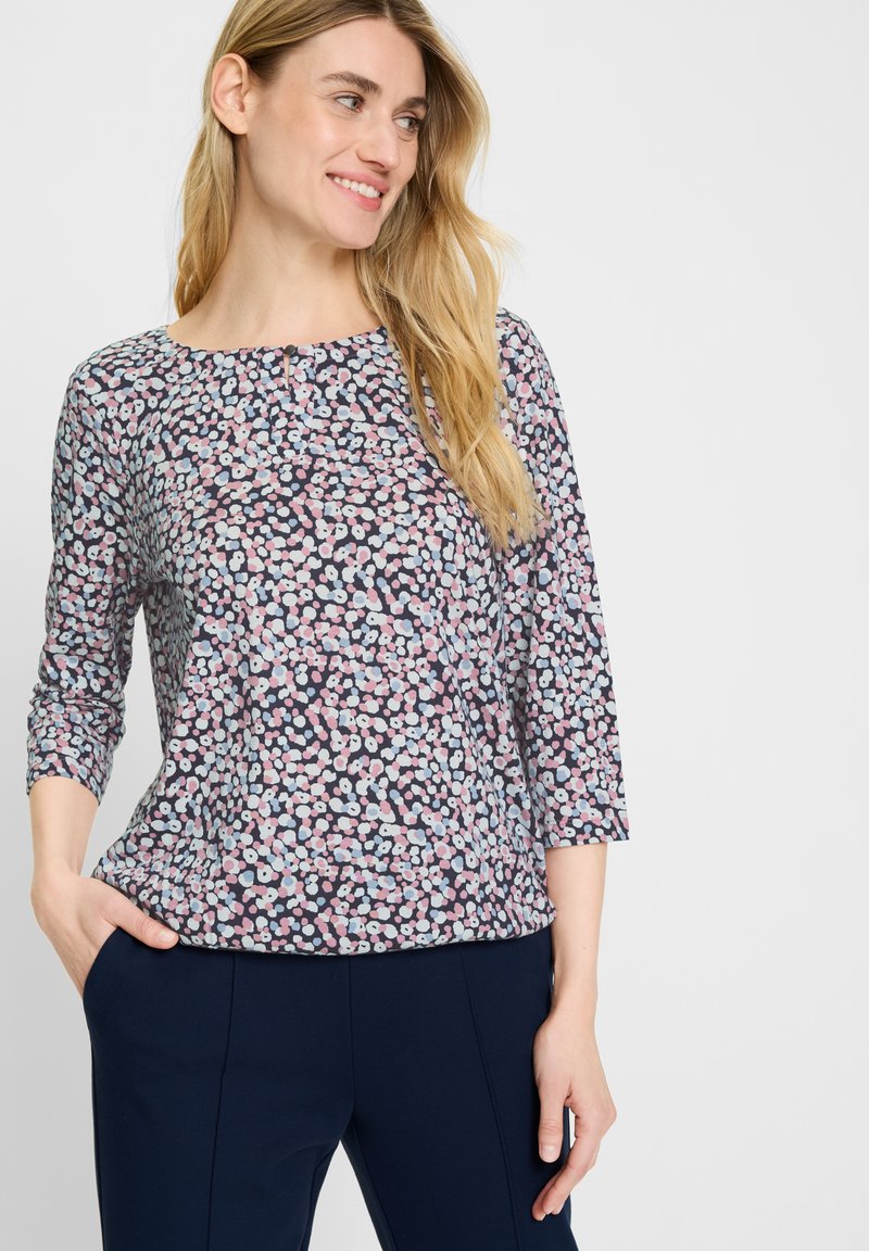 Blusenshirt mit floralem Muster in Dunkelblau, mit rundem Ausschnitt und dreiviertellangen Ärmeln. Das Design umfasst kleine pinke und blaue Blumen.