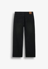 Jean noir à jambe droite vu de dos avec deux poches et une petite étiquette de marque en cuir marron sur la ceinture.