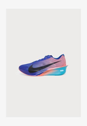 Chaussure de course Nike bleue et rose avec un grand swoosh noir et une semelle épaisse bleue et orange, vue de côté sur fond blanc.