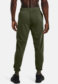 Gröna sweatpants med elastisk midja, smalnade muddar och sidofickor, tillverkade av ett mjukt, andningsbart material.