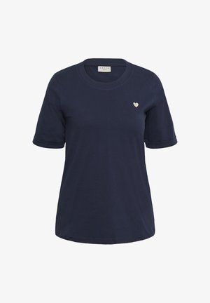 T-shirt bleu marine à manches courtes avec encolure ronde et petit emblème en forme de cœur blanc sur la poitrine gauche.