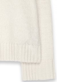 Šviesiai smėlinės spalvos megztinis su briaunotu apvadu ir rankovėmis. Minkšta tekstūra ir laisvas audimas. Yra sumažinto peties dizainas, užtikrinantis atsipalaidavusį prigludimą.