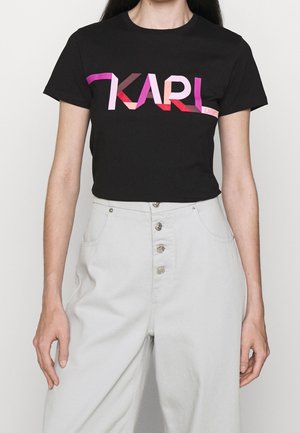 Camiseta de algodón negra con un gráfico audaz y multicolor "KARL" en tonos rosa y rojo. Mangas cortas y cuello redondo.