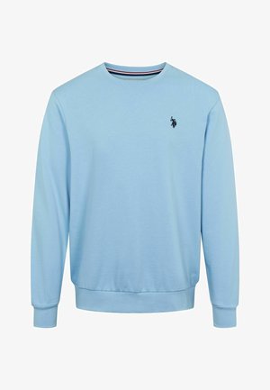 Lys blå genser laget av bomull med rund hals, ribbestrikkede mansjetter og nederkant. Har en liten svart logo på brystet.