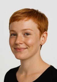 Silverfärgad örhänge i form av en fjäril, buren av en person med kort rött hår och fräknar, mot en neutral bakgrund som framhäver örhängets detaljer.