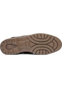 Suela de zapato de goma marrón con profundos surcos para tracción, que presenta un logo circular y una superficie texturizada para un mejor agarre.