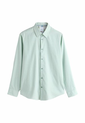 Cămașă verde deschis cu mânecă lungă, cu nasturi și guler ascuțit, cu model floral pe interiorul gulerului, așezată plat pe un fundal alb.