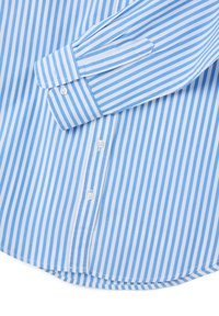 Manchette de chemise à rayures verticales bleu clair et blanches, avec patte de boutonnage visible, sur fond blanc.