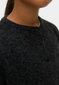 Schwarzer Wollcardigan mit flauschiger Textur und rundem Ausschnitt, der an der Vorderseite mit zwei schwarzen Knöpfen verschlossen wird.