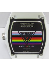 Witte digitale horloge met een vierkant gezicht, voorzien van een gekleurde regenboogstreep ontwerp en het "GUESS" logo. Waterdicht, roestvrijstalen achterkant.