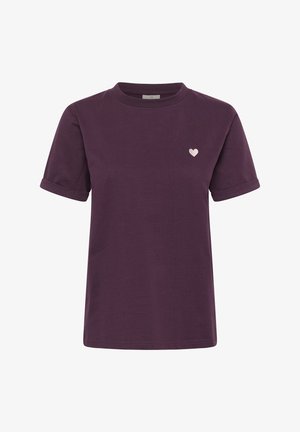 T-shirt violet foncé à manches courtes avec des revers roulés et un petit emblème en forme de cœur rose clair sur le côté gauche de la poitrine.