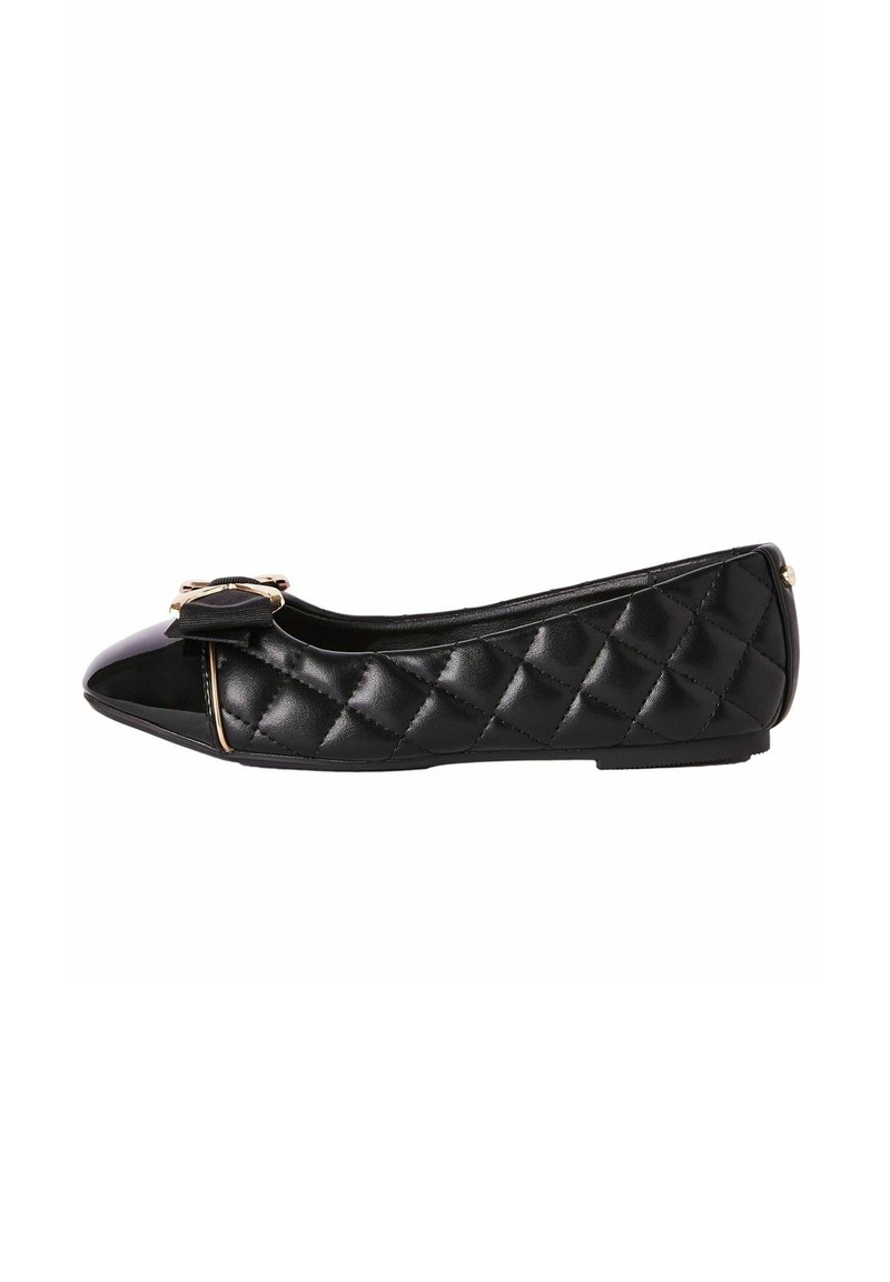Bailarinas negras con textura acolchada, puntera de charol brillante y un lazo decorativo en la parte delantera, que presentan un perfil bajo y una suela flexible.