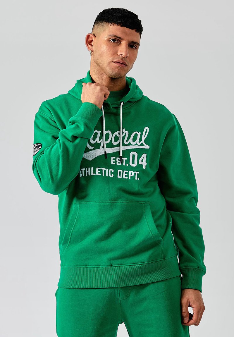 Haut à capuche en coton vert avec une poche kangourou, une capuche à cordon et un texte graphique blanc. Manches et ourlet côtelés, tissu de poids moyen.
