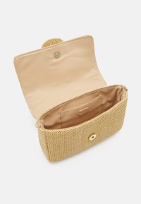 Guldhandväska med bambu-textur och knappstängning; inuti har den en slät beige foder och en liten kortficka.