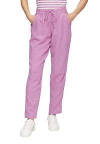 Roze linnen joggerbroeken met een elastische tailleband en een koord, voorzien van twee zijzakken en een ontspannen pasvorm. Gecombineerd met witte sneakers.