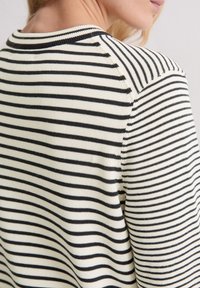 Schwarz-weißer, gestreifter Strickpullover mit rundem Ausschnitt und gerippten Bündchen. Er zeichnet sich durch eine glatte Textur und sichtbare Nahtdetails aus.