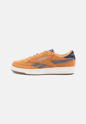 Reebok-Sneaker aus orangefarbenem Wildleder mit blauen Akzenten. Verfügt über einen gepolsterten Schaft, ein flaches Schnürdesign und eine weiße Gummisohle.